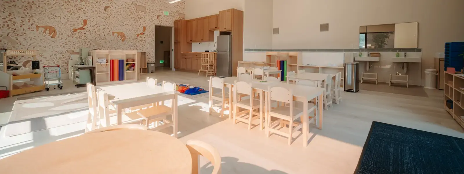 Bright Montessori classroom with woodland mural