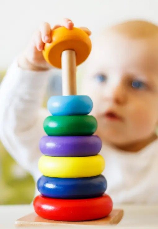 young child playing with colorful rings